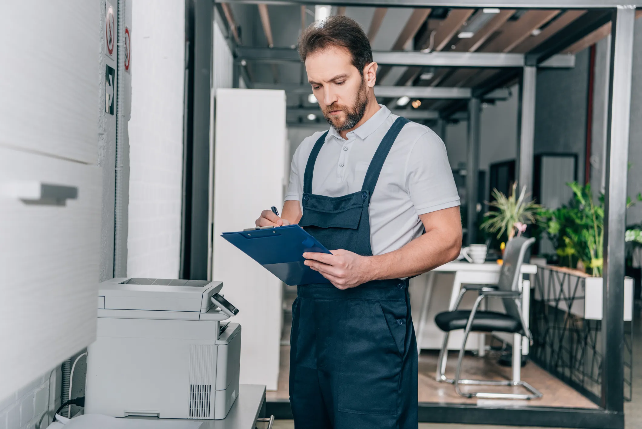 Webdesigner arbeitet konzentriert im modernen Büro mit Drucker