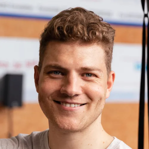 Lächelnder Webdesigner aus Münster im Büro mit freundlichem Gesichtsausdruck