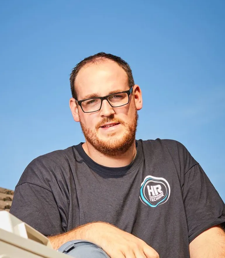 Webdesigner aus Münster mit Brille vor blauem Himmel, HR-Technik T-Shirt