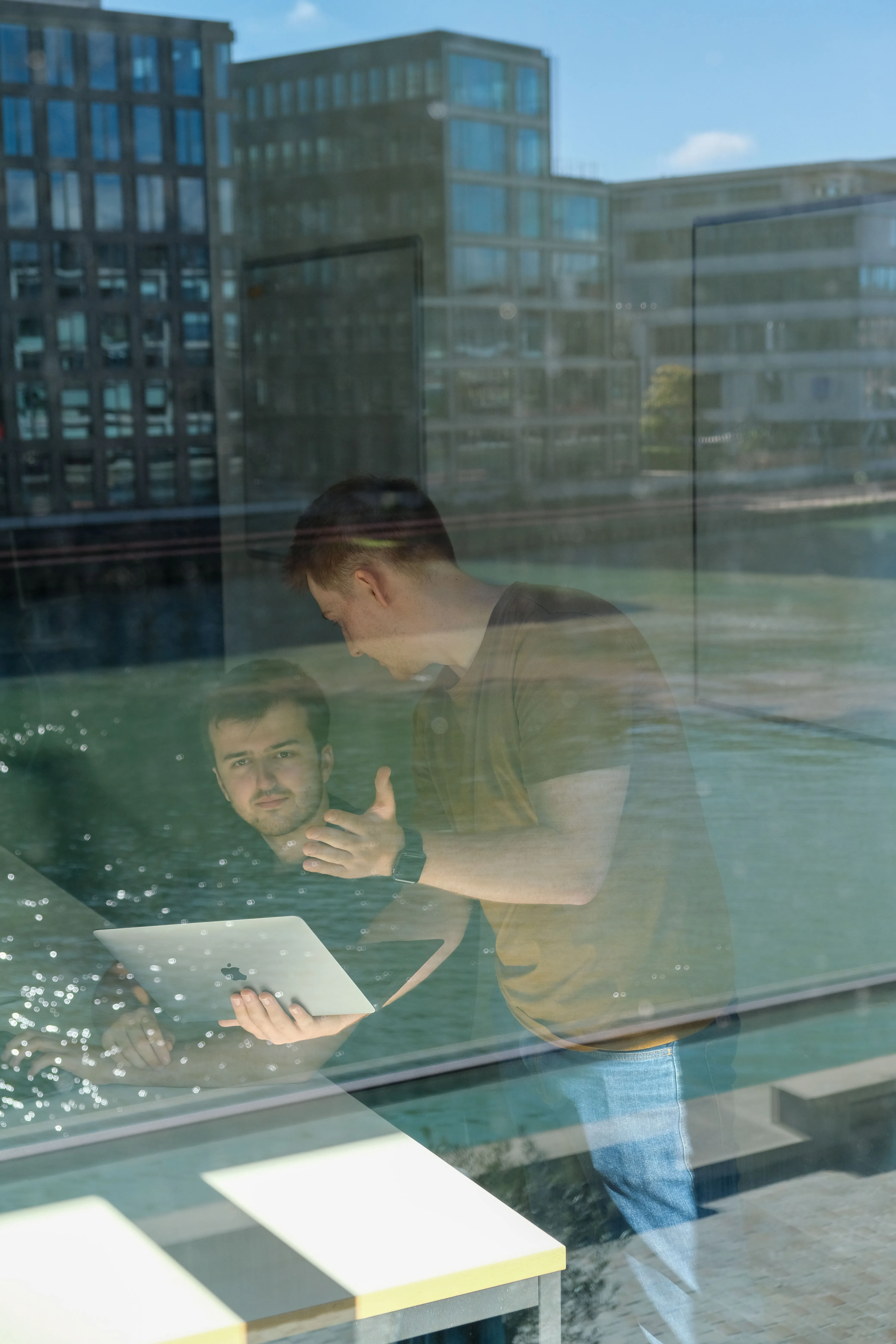 Webdesign-Team in Münster arbeitet zusammen am Laptop im modernen Bürogebäude